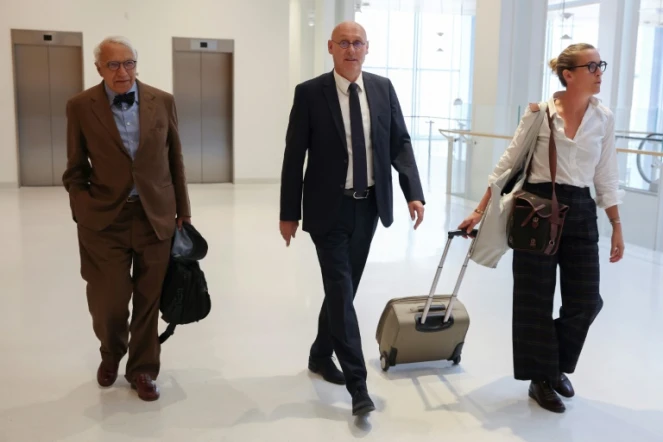Le président de la Fédération française de rugby Bernard Laporte (C), flanqué des avocats français Jean-Pierre Versini-Campinchi (G) et Fanny Colin (D) arrive au tribunal des Batignolles, le 7 septembre 2022