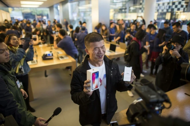 Un homme pose avec son nouvel iPhone X dans une boutique Apple à Pékin, le 3 novembre 2017