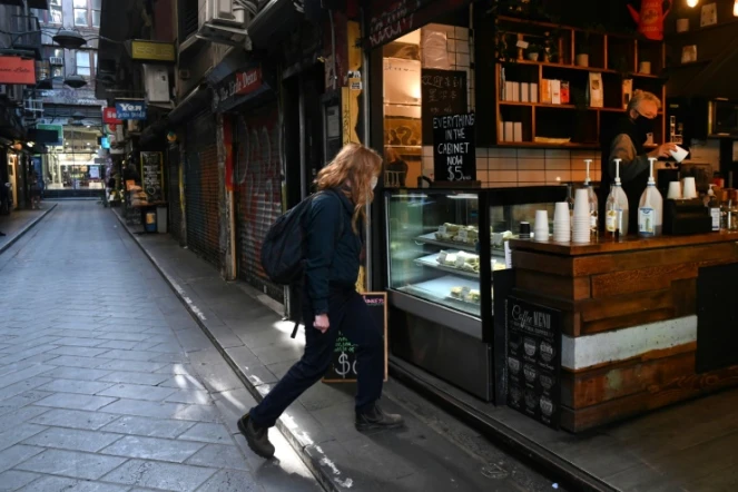 Une femme entre dans un café dans une rue normalement animée du quartier d'affaires de Melbourne, le 6 août 2020 en Australie