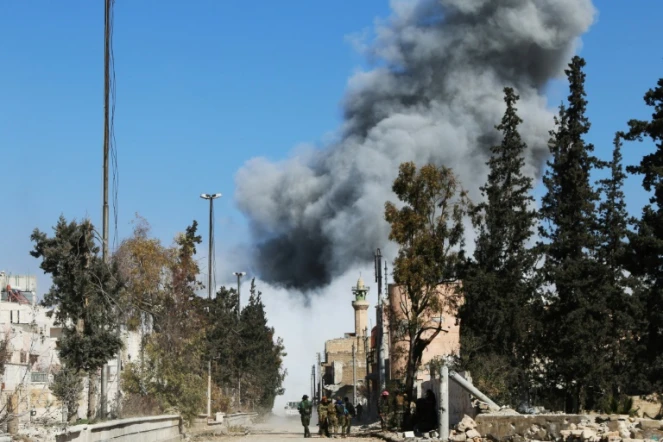 Des combattants rebelles pro-turcs dans une rue de Al-Bab, après un raid aérien sur une position de l'EI, le 21 février 2017 en Syrie