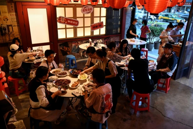 Des habitants dînent à la terrasse d'un restaurant, le 6 juin 2022 à Pékin
