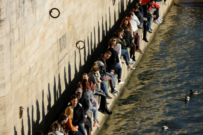 Des personnes se rassemblent le long de la Seine pour profiter d'un après-midi ensoleillé, à Paris, le 28 février 2021