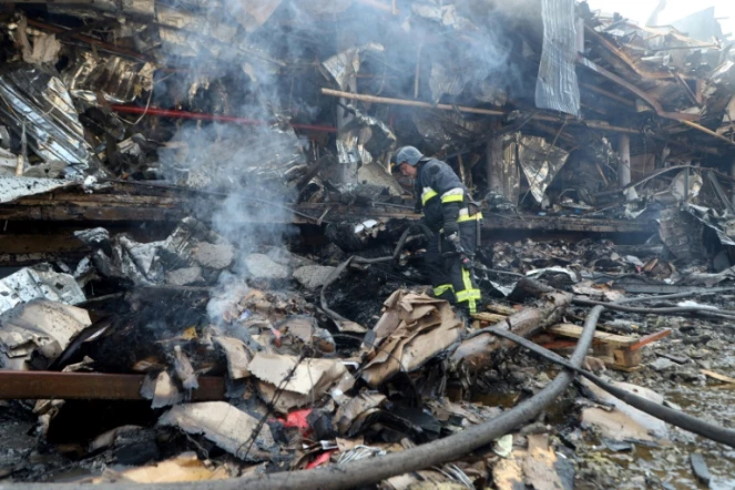 Un pompier ukrainien travaille à l'extérieur d'un supermarché détruit par une attaque nocturne, à Odessa, le 14 août 2023