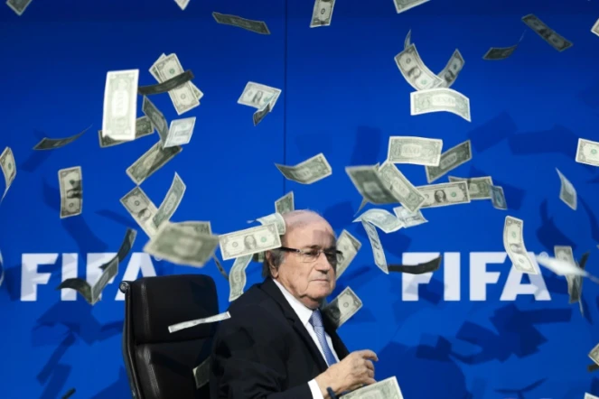 Le président démissionnaire de la Fifa Joseph Blatter reçoit des faux dollars lancés par un manifestant, le 20 juillet 2015 à Zurich