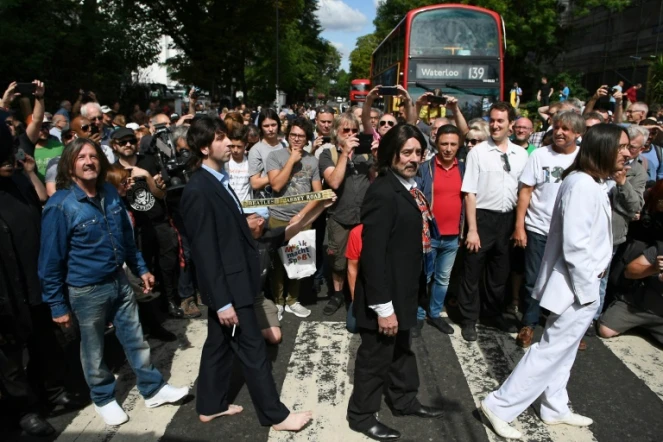 Des sosies traversentle passage piétons d'Abbey Road, rendu célèbre par les Beatles 50 ans plus tôt, le 8 août 2019 à Londres 