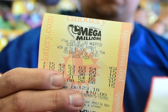 Un homme montre son ticket avant le tirage du super jackpot de 1,6 milliard, acheté dans une épicerie de Hawthorne, en Californie, le 23 octobre 2018