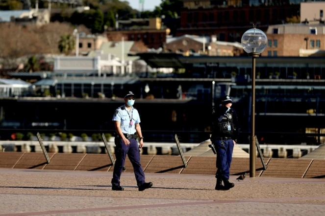 Des policiers patrouillent dans le quartier de l'opéra de Sydney, où le confinement a été prolongé pour au moins deux semaines