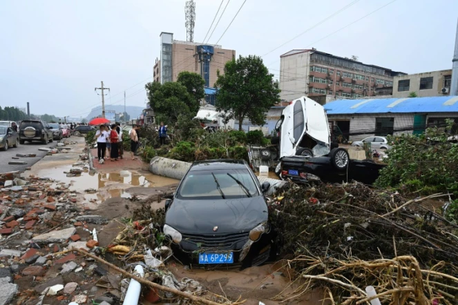 La population constate les dégâts après les intempéries à Mihe, dans la province de Henan (centre de la Chine), le 22 juillet 2021