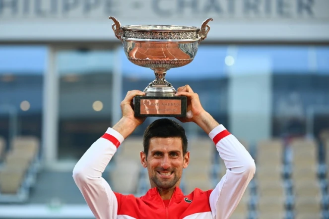 Le Serbe Novak Djokovic brandit son trophée après sa victoire en finale contre le Grec Stefanos Tsitsipas, à Roland-Garros, le 13 juin 2021