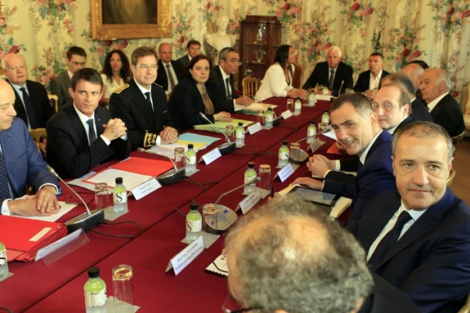 Le Premier ministre Manuel Valls (G) entouré à G du ministre des Collectivités Jean-Michel Baylet et à D du préfet de Corse Bernard Schmeltz devant le président de l'Assemblée de Corse Jean-Guy Talamoni (D) à Ajaccio le 4 juillet 2016
