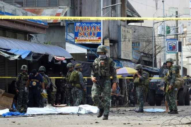 Des policiers et soldats sur les lieux d'un double attentat contre la cathédrale de Jolo, le 27 janvier 2019 aux Philippines