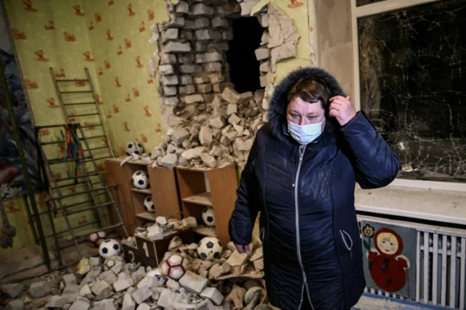 Une femme se tient parmi les décombres dans une école maternelle touchée par des obus séparatistes, à Stanitsa Louganska en Ukraine le 17 février 2022