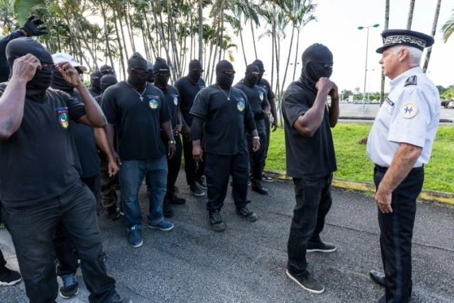 Les membres du groupes "les 500 frères en délinquance", face à la police lors d'une manifestation en soutien à la grève générale à Guyane, le 29 mars 2017