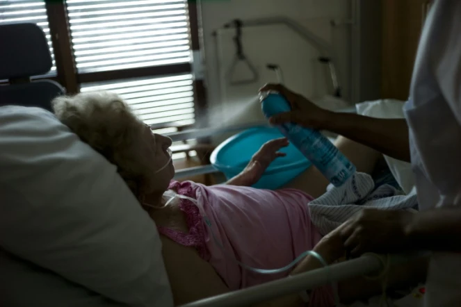 Une infirmière asperge d'eau une personne âgée qui souffre de la chaleur, le 22 juillet 2013 dans un hôpital d'Argenteuil, près de Paris 