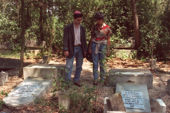 Des proches se recueillent devant les tombes profanées au cimetière de Carpentras, le 11 mai 1990