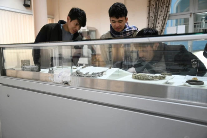 Des visiteurs admirent des objets du musée national d'Afghanistan, le 12 décembre 2021 à Kaboul