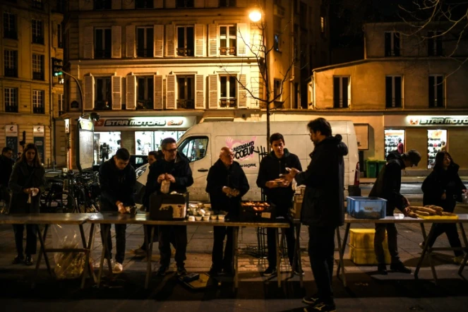 Des bénévoles des "Restos du coeur" mettent en place un point de distribution alimentaire, à Paris le 21 mars 2023