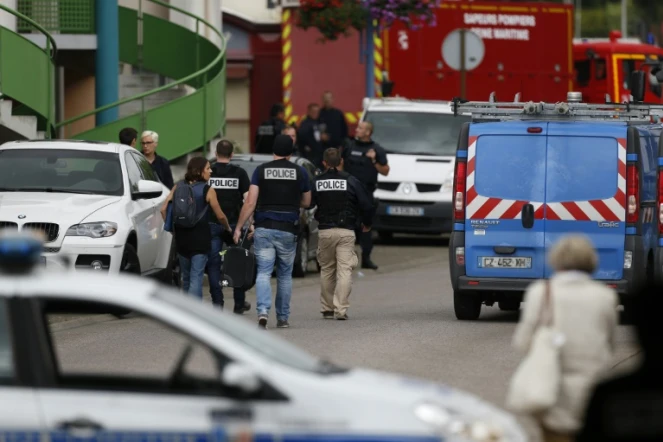 Policiers et pompiers se positionnent autour de l'église de Saint-Etienne-de-Rouvray où a eu lieu une prise d'otages et où un prêtre a été égorgé, le 26 juillet 2016