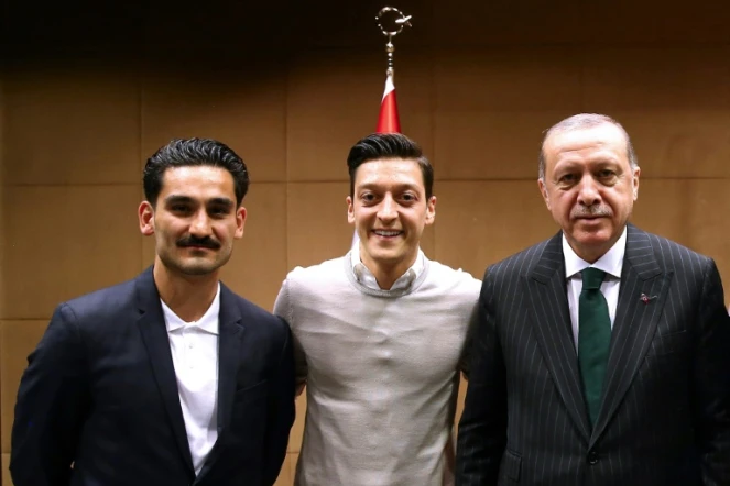 Les footballeurs allemand d'origine turque Ilkay Gundogan (g) et Mesut Özil (c) posent avec le président turc Recep Tayyip Erdogan, le 13 mai 2018