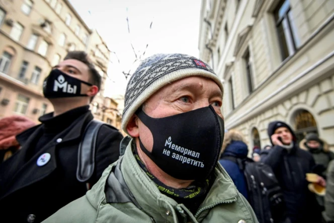 Des manifestants portant des masques frappés du logo de l'ONG Mémorial sont rassemblés devant la Cour suprême à Moscou le 28 décembre 2021