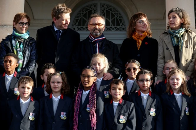 Le maire de Béziers, Robert Ménard (au centre), à côté d'élèves en uniforme dans la cour de l'école primaire du Château de la Chevaliere à Béziers, le 26 février 2024