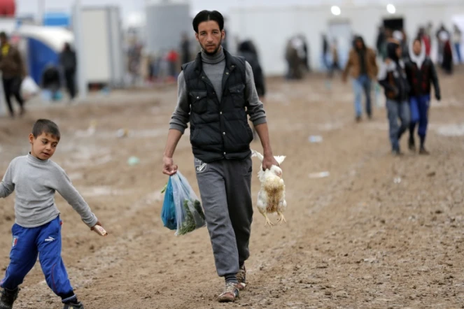 Un déplacé du nord de l'Irak, dans le camp d'Al-Khazir, rapporte des provisions, le 1 décembre 2016