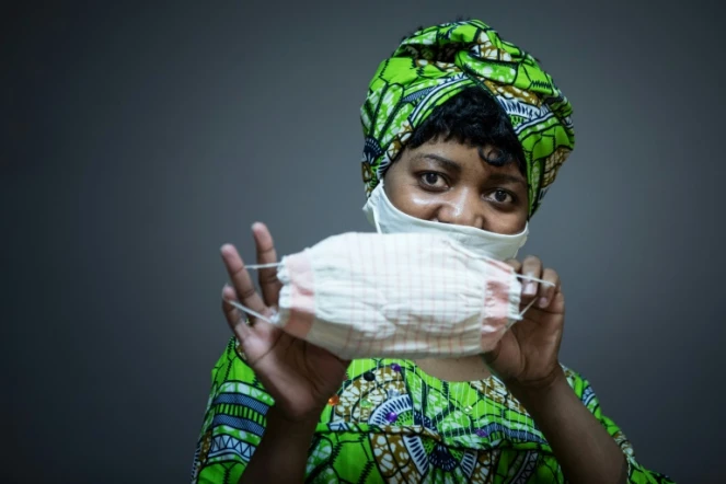 La camerounaise Florence pose avec un masque qu'elle a réalisé pour l'organisation caritative de l'Armée du Salut, à Paris le 6 avril 2020