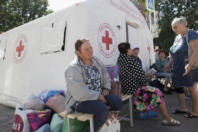Des personnes déplacées par les combats reçoivent une aide humanitaire au point de distribution de la Croix-Rouge russe à Koursk, le 15 août 2024