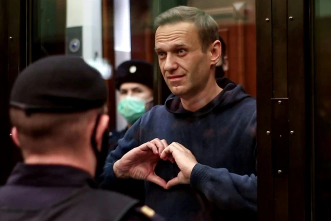 L'opposant russe AlexeI Navalny, dans sa cage de verre pendant son procès à Moscou, dessine un coeur avec les mains, le 2 février 2021 sur une photo fournie par les services judiciaires de Moscou
