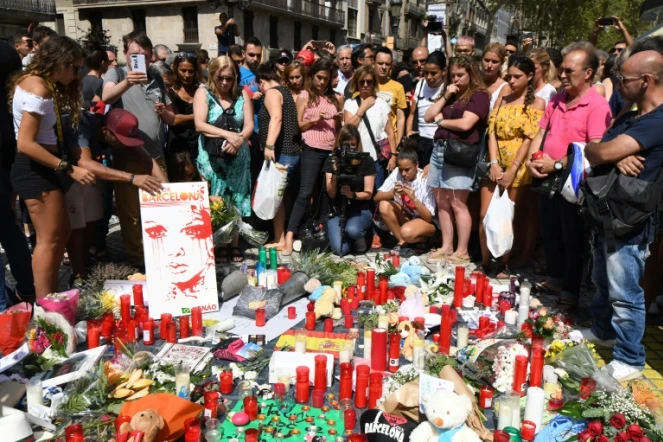 Des passants rendent hommage le 18 août 2017 aux victimes de l' attentat de la Rambla de Barcelone qui a fait 13 morts