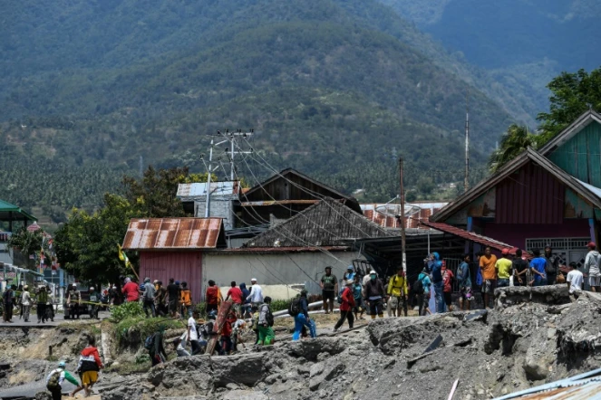 Des habitants marchent le 2 octobre 2018 au milieu des décombres dans le village de Perumnas Balaroa (Indonésie).