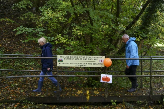 Des promeneurs traversent la frontière entre l'Angleterre et le Pays de Galles le 21 octobre 2020 à Knighton