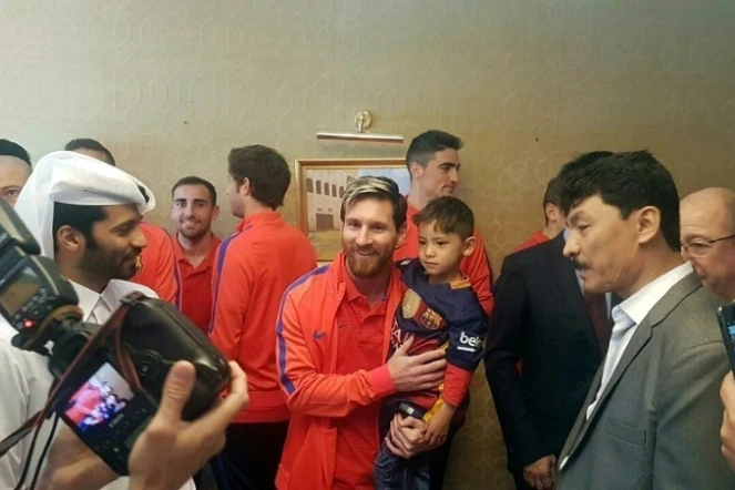 L'attaquant argentin du FC Barcelone Lionel Messi (C) tient dans ses bras le jeune Afghan Murtaza Ahmadi, le 13 décembre 2016 à Doha