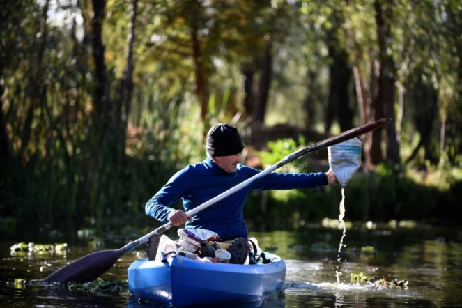 Omar Menchaca récupère des déchets en plastique dans les eaux des canaux de Xochimilco, le 25 janvier 2022 au Mexique