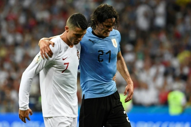 L'attaquant uruguayen Edinson Cavani blessé quitte le terrain soutenu par le Portugais Cristiano Ronaldo lors des 8e de finale du Mondial le 30 juin 2018