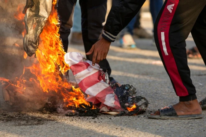 Des Irakiens brûlent le drapeau américain pour protester contre la présence des Etats-Unis, à Bassora, dans le sud de l'Irak, le 30 décembre 2019