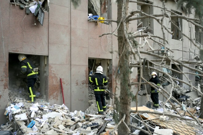 Des pompiers dégagent les décombres du bâtiment de l'administration régionale de Mykolaïv touché par des roquettes russes en Ukraine, le 29 mars 2022