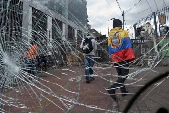 Un manifestant indigène enveloppé d'un drapeau équatorien près d'une barricade au voisinage de l'Assemblée nationale, à Quito le 26 juin 2022