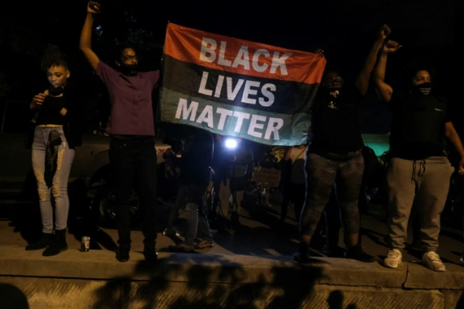 Des manifestants tiennent un drapeau "Black Lives Matter" devant la First Unitarian Church, le 25 septembre 2020 à Louisville, dans le Kentucky