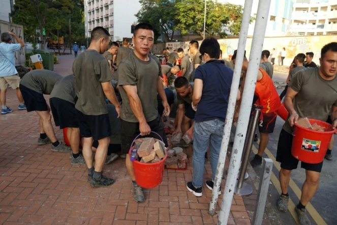 Des militaire de la caserne de l'armée chinoise à Hong Kong aident à nettoyer les rues après une semaine de perturbations le 16 novembre 2019