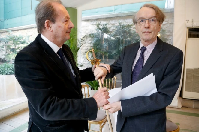 L'écrivain Patrick Grainville (D) reçoit son épée d'académicien des mains de Jean-Marie Rouart (G), membre de l'Académie française, le 18 février 2019 à Paris