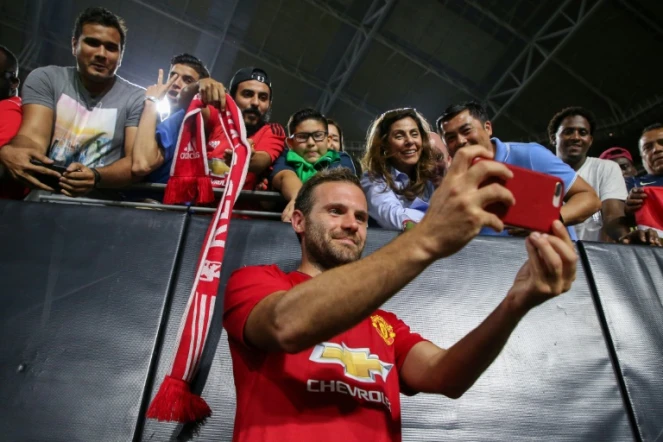 L'attaquant de Manchester United Juan Mata prend des photos avec des supporters après un match de pré-saison contre les Mexicains de Club America, le 19 juillet 2018 à Glendale près de Phoenix