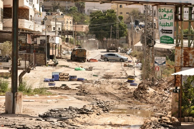 Des véhicules blindés de l'armée israélienne roulent sur une route lors d'un raid dans le camp de réfugiés palestiniens d'al-Faraa, près de la ville de Toubas, en Cisjordanie occupée, le 28 août 2024