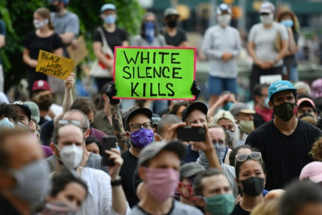 Des manifestants blancs, l'un armé d'une pancarte disant "le silence blanc tue", lors d'une manifestation à Brooklyn le 5 juin 2020 