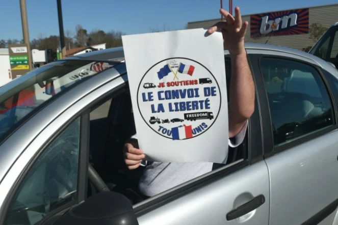 Un homme tient une affiche "Le convoi de la liberté" depuis sa voiture à Bayonne, le 9 février 2022