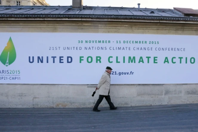 Un homme passe devant un panneau annonçant la tenue de la conférence de Paris (COP 21) sur le climat, le 14 janvier 2015