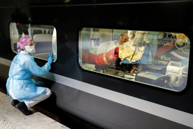 Une infirmière surveille l'installation d'un malade dans un train médicalisé à la Gare d'Austerlitz à Paris, le 1er avril 2020