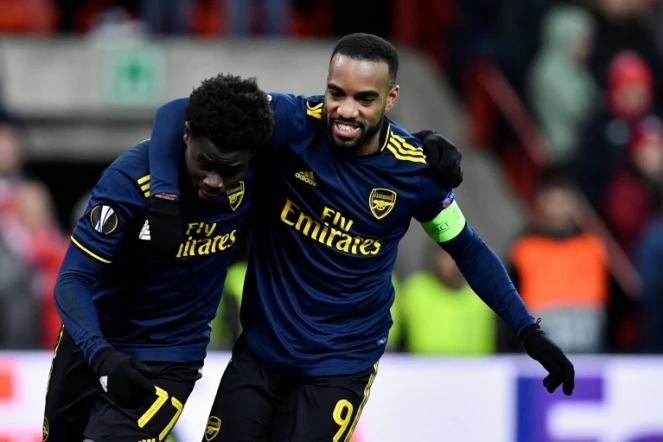 Les attaquants d'Arsenal Bukayo Saka (g) et Alexandre Lacazette heureux après un but du premier sur le terrain du Standard de Liège en Ligue Europa, le 12 décembre 2019