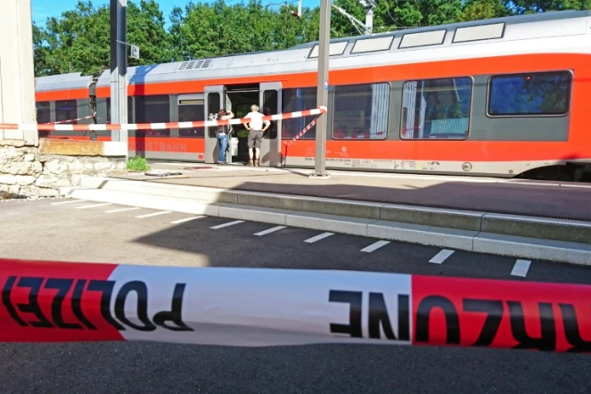 Des policiers aux abords d'un train à la station de Salez (est de la Suisse) après qu'un homme a mis le feu à un wagon et poignardé des passagers, le 13 août 2016 