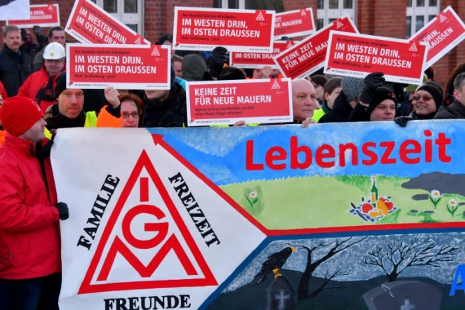 Des ouvriers de l'usine Bombardier brandissent des panneaux au logo du syndicat allemand de la métallurgie IG Metall, à Hennigsdorf près de Berlin (nord-est), le 8 janvier 2018